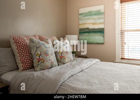 Camera da letto calda e accogliente con biancheria da letto Cottage Core e cuscini Throw Foto Stock