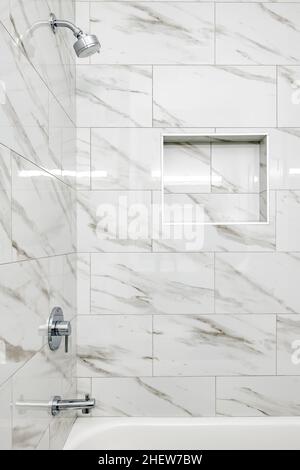 Moderno Bianco e Grigio Grande piastrella in marmo nella vasca da bagno con rientranza in tolette a muro e strutture in acciaio inox Foto Stock