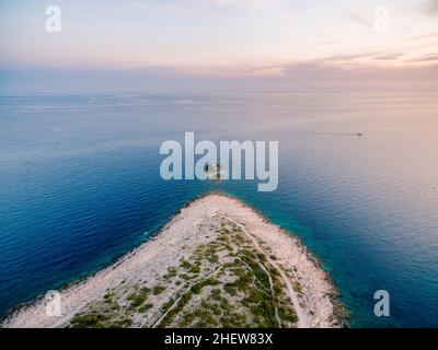 Faro sull'isola di fronte al promontorio di Punta Planca. Drone Foto Stock