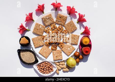 Makar sankrant festival cibo speciale Peanut chikki, Til chikki bar fatto di gelificazione, semi di sesamo e noci macinate. Anche mangiato frutta jujube e pooja Foto Stock