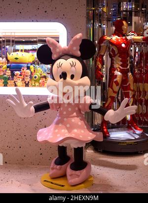 Allegro spettacolo Minnie benvenuto a braccia aperte sul davanti di un negozio di giocattoli Foto Stock