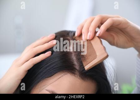 Mattina di giovane donna pettinare i capelli a casa Foto Stock