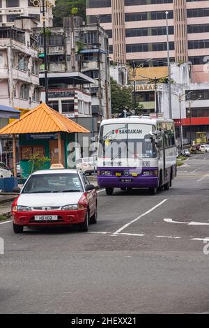 Sandakan, Malesia - 05 gennaio 2022: Taxi vecchio e un autobus vecchio nella città di Sandakan. Autobus in auto nel traffico cittadino. Trasporto pubblico a Sabah, Borneo Foto Stock