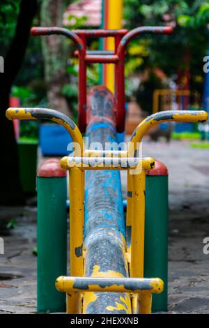 Primo piano di metallo colorato vuoto vedere i bambini visto sul parco giochi della città pubblica Foto Stock