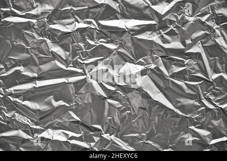Primo piano della struttura in lamina di alluminio argentato sbriciolato. Sfondo astratto per il design. Foto Stock