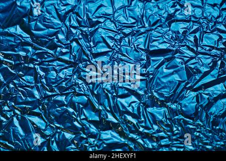 Primo piano della struttura in lamina di alluminio argentato con motivo blu. Sfondo astratto per il design. Foto Stock