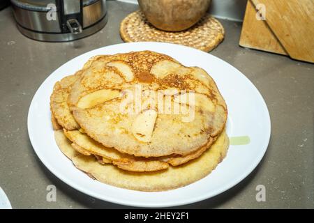 L'Apfelpfannkuchen, o frittelle di mele tedesche, è una colazione leggera e gustosa, piena di fette di mele dolci e caramellate. Foto Stock