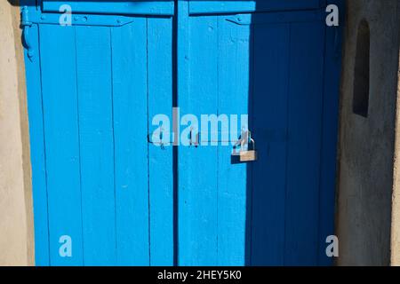 antica porta di legno dipinta di blu con serratura sul lato destro Foto Stock