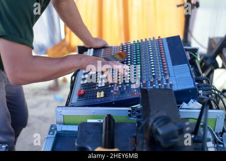 Sistema audio e un tecnico audio maschile che lavora su una console di mixaggio audio Foto Stock