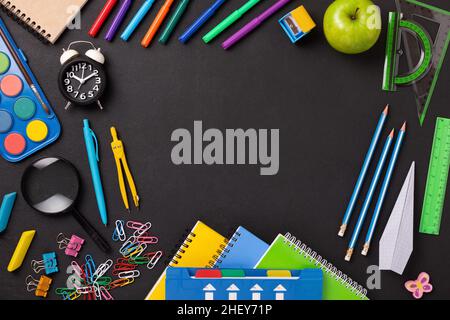 Telaio fatto di forniture scolastiche e cancelleria su sfondo nero con spazio per la copia Foto Stock