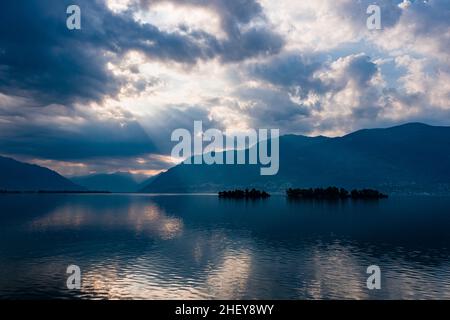 Drammatiche nuvole di tuglio sul Lago maggiore, riflettendo sulla superficie dell'acqua. Foto Stock