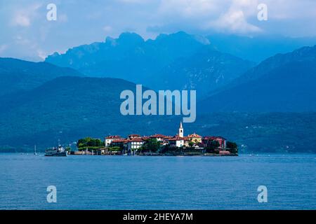 Vista sull'isola di Isola superiore, la torre della chiesa di San Vittore che si erge sul Lago maggiore, circondando montagne in lontananza. Foto Stock