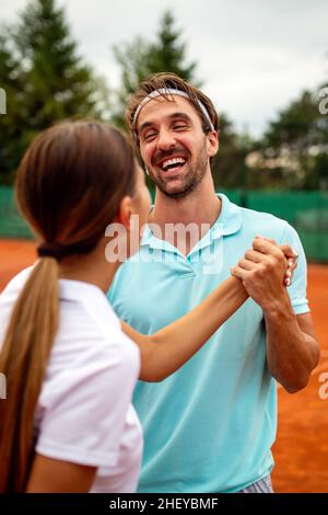 Gruppo di giocatori di tennis che danno una stretta di mano dopo una partita Foto Stock