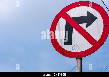 non girare a destra in direzione del traffico sotto la luce del sole e il cielo blu chiaro Foto Stock