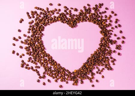 Tazza di caffè su sfondo viola con forma udibile realizzata con chicchi di caffè. Concetto ideale per una giornata di caffè più allegro, un giorno di baristi internazionali o Foto Stock