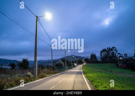 Illuminato strada vecchia, rurale in serata nuvolosa, Torres Vedras, Portogallo Foto Stock