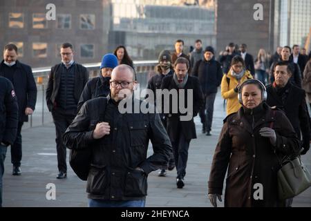 I lavoratori della città camminano attraverso il London Bridge mentre il sole sorge ad est mentre viaggiano nella City of London in una mattinata di inverni chiari, City of London, UK 13th gennaio 2022. Londra, Inghilterra, Regno Unito Credit: Jeff Gilbert/Alamy Live News Foto Stock