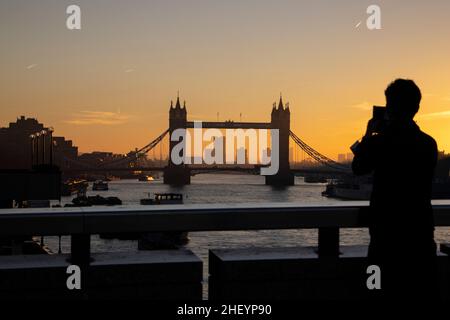 I lavoratori della città camminano attraverso il London Bridge mentre il sole sorge ad est mentre viaggiano nella City of London in una mattinata di inverni chiari, City of London, UK 13th gennaio 2022. Londra, Inghilterra, Regno Unito Credit: Jeff Gilbert/Alamy Live News Foto Stock