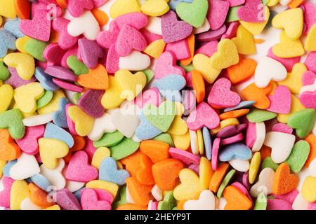 Pasta colorata a forma di cuore cosparge da vicino il biglietto d'auguri per San Valentino minimalistico Foto Stock