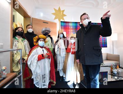 Erfurt, Germania. 13th Jan 2022. Bodo Ramelow (Die Linke, r), primo Ministro della Turingia, riceve cinque cantanti carolesi da Erfurt nella Cancelleria dello Stato della Turingia e mostra loro il suo ufficio. Sotto il motto 'Get sano - rimanere in buona salute. Un diritto del bambino in tutto il mondo", l'Epifania di quest'anno si concentra sull'assistenza sanitaria per i bambini in Africa. Il primo Ministro Ramelow ha consegnato una donazione di 500 euro all'organizzazione missionaria dei bambini "Die Sternsinger" e.V. Credit: Martin Schutt/dpa-Zentralbild/dpa/Alamy Live News Foto Stock