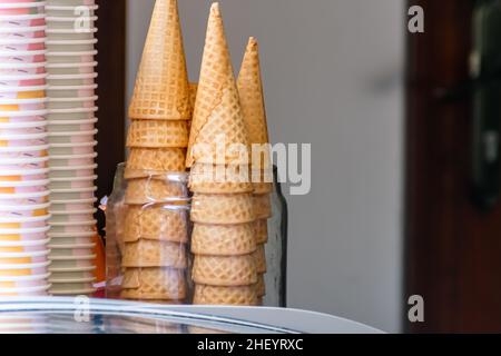 un mucchio di croccanti coni di cialde per gelato di colore marrone si trova sul negozio Foto Stock
