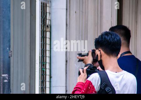 due giovani fotografi che lavorano sul loro lavoro per scattare qualche bella foto con le loro macchine fotografiche sul marciapiede della città Foto Stock