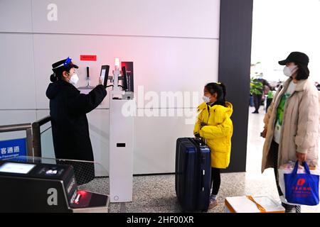 QINGDAO, CINA - 13 GENNAIO 2022 - Un ispettore dei biglietti controlla il biglietto di un passeggero alla stazione ferroviaria di Qingdao West, provincia di Shandong della Cina orientale, Ja Foto Stock