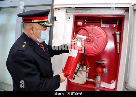 QINGDAO, CINA - 13 GENNAIO 2022 - Yuan Youkun, un agente antincendio, controlla le strutture antincendio presso la stazione ferroviaria di Qingdao West, Shandong della Cina orientale Foto Stock