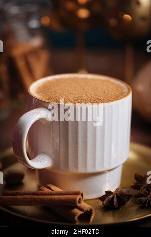 Tazza di spezia di zucca tardiva o di eggnog con bastoncini di cannella, anice stellato di zucche e noce moscata in un ambiente rustico e vintage Foto Stock