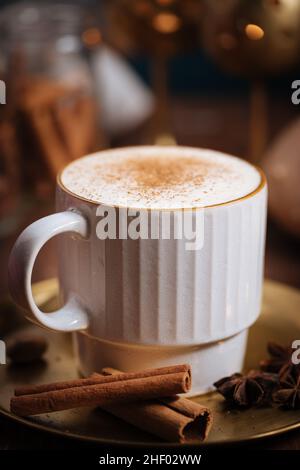 Tazza di spezia di zucca tardiva o di eggnog con bastoncini di cannella, anice stellato di zucche e noce moscata in un ambiente rustico e vintage Foto Stock