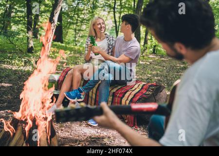 Intera lunghezza del corpo foto giovane coppia che rimane in campeggio con gli amici in estate fuoco che brucia alcol potabile Foto Stock