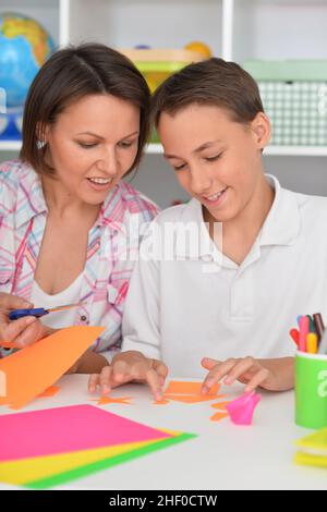 Porait di madre insegna al figlio di fare oggetti artigianali Foto Stock