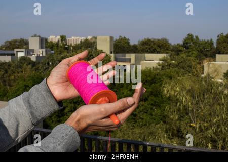 Maschio mani che trattengono il rotolo di bobina di kite chiamato manjha di phirki. Ragazzo volante aquilone in India kite festival di Makarsankrant o Uttaraya, pongal, lohri on Foto Stock