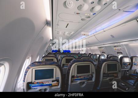 L'interno dell'aeromobile. Cabina vuota dell'aereo. File di sedili  passeggeri con schermi nei poggiatesta Foto stock - Alamy