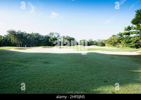 Vista panoramica di un campo da golf con trappole di sabbia e cielo blu in Messico Foto Stock