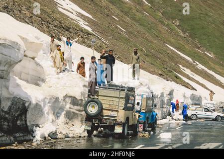 Gilgit, Pakistan - 08 giugno 2018: Le persone pakistane raccolgono neve e caricano l'auto in montagna Foto Stock