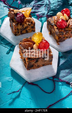 Ricco dolce budino natalizio carico di frutta secca, noci e spezie su un vibrante sfondo turchese orientale Foto Stock