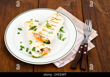 Lavash sottile con verdure e pollo sul piatto, shawarma. Foto Foto Stock