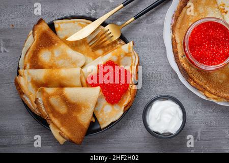 Pila di sottili pancake frullati blini con caviale rosso Foto Stock