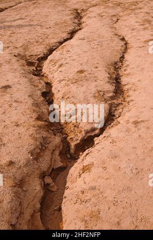 Paesaggio naturale di crepe in terra rossa asciutta sembra paesaggio marziano. Sfondo naturale testurizzato. Foto Stock