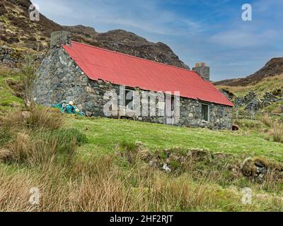 Vecchia casa in pietra croft con tetto in stagno rosso, Moilingeanais, Isola di Harris, Scozia, Regno Unito Foto Stock