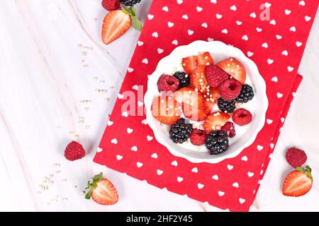 Vista dall'alto della ciotola di yogurt con fragola, lampone e frutta di mora e quinoa soffiato Foto Stock