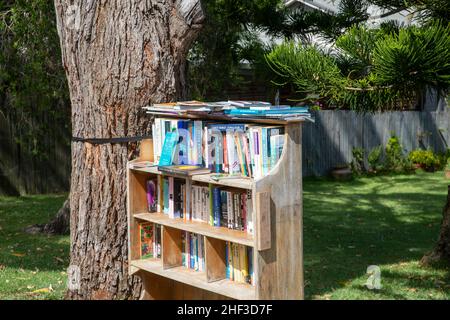 Mini biblioteca di strada al di fuori di una casa di Sydney a Avalon Beach per donare, prendere in prestito e donare libri per le persone di accedere e leggere, Australia Foto Stock