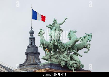 Statue sul Grand Palais di Parigi . Statua di bronzo di cavalli volanti e carro . Bandiera francese in alto Foto Stock