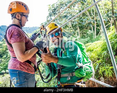 Ziplining in Puerto Rico guida preparare il pilota in imbracatura Foto Stock