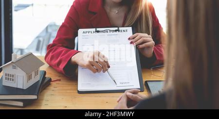 Primo piano di Business donna o agente che punta e firma accordo per la casa d'acquisto. Concetto di Bank manager. Foto Stock