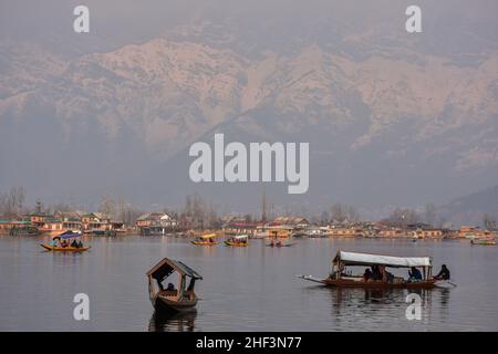 Srinagar, India. 13th Jan 2022. I boatmen sono visti con i turisti nelle loro barche durante una fredda giornata invernale. (Foto di Saqib Majeed/SOPA Images/Sipa USA) Credit: Sipa USA/Alamy Live News Foto Stock