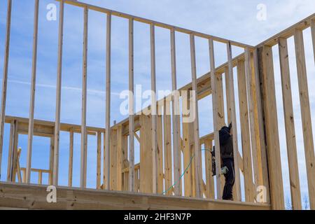 Un carpentiere per chiodare travi di legno con un martello pneumatico Foto Stock