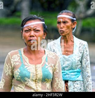 Donne balinesi vestite in sarong batik e baju tradizionali in una cerimonia che si svolge nel villaggio di Ketewel a Gianyar, Bali, Indonesia Foto Stock