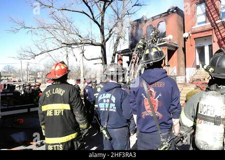 St. Louis, Stati Uniti. 13th Jan 2022. I vigili del fuoco di St. Louis osservano l'edificio bruciato dopo aver ricevuto la notizia che uno dei loro è stato ucciso e un altro ferito mentre combattevano un incendio a St. Louis giovedì 13 gennaio 2022. I vigili del fuoco tentarono di uscire dalla casa vacante quando il tetto crollò intrappolando i due finché gli altri li tirarono fuori. La morte è il primo vigile del fuoco di St. Louis a morire in un incendio in vent'anni. Foto di Bill Greenblatt/UPI Credit: UPI/Alamy Live News Foto Stock